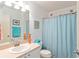 Well-lit bathroom featuring a blue patterned shower curtain and beach themed decor at 2063 Thornton Ter, The Villages, FL 32162