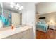 Bathroom with a well-lit vanity area, sink, and access to an adjacent bedroom at 2063 Thornton Ter, The Villages, FL 32162
