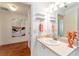Bright bathroom with a vanity, decorative seahorse, and open shelving at 2063 Thornton Ter, The Villages, FL 32162