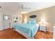 Bedroom with a plush bed, hardwood floors, and a dresser with decorative accents at 2063 Thornton Ter, The Villages, FL 32162