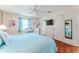 Comfortable bedroom with a plush bed, hardwood floors, and a window with blue curtains at 2063 Thornton Ter, The Villages, FL 32162