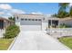 Well-maintained single-story home with white siding, two-car garage, and a tidy landscaped front yard at 2063 Thornton Ter, The Villages, FL 32162