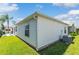 Side view of the house with a well-maintained lawn and an outdoor patio space at 2063 Thornton Ter, The Villages, FL 32162