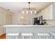 Modern kitchen with stainless steel appliances, white cabinets, breakfast bar, and adjacent dining area at 2063 Thornton Ter, The Villages, FL 32162