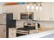 Modern kitchen featuring stainless steel appliances and overhead lighting at 2063 Thornton Ter, The Villages, FL 32162