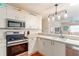 Bright kitchen featuring modern appliances with an open view into the living room at 2063 Thornton Ter, The Villages, FL 32162