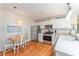 Well-lit kitchen boasts stainless steel appliances, a cozy breakfast nook, and wood-look flooring at 2063 Thornton Ter, The Villages, FL 32162