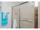 Bathroom shower with glass door, tile surround, and a mounted shower head at 2063 Thornton Ter, The Villages, FL 32162