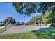 A basketball court surrounded by trees, featuring green and red surfaces with lighting for evening play at 2126 Burley Ave, Clermont, FL 34711