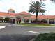 Clubhouse exterior featuring a portico, red tile roof, and lush landscaping at 2126 Burley Ave, Clermont, FL 34711