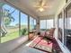 Bright sunroom featuring windows, a red rug, chairs, and green views at 2126 Burley Ave, Clermont, FL 34711