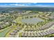 Aerial view of a planned community featuring a golf course, lake, and lush greenery at 2129 Palm Tree Dr, Poinciana, FL 34759