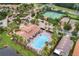 Aerial view of a community pool, clubhouse, and tennis courts surrounded by palm trees at 2129 Palm Tree Dr, Poinciana, FL 34759