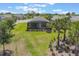 Spacious backyard featuring lush green grass, mature palm trees, and screened in patio at 2129 Palm Tree Dr, Poinciana, FL 34759