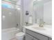 Bright bathroom with a shower over tub, white tile and gray vanity at 2129 Palm Tree Dr, Poinciana, FL 34759