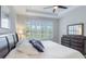 Relaxing bedroom offers tray ceiling, window shutters, a plush bed, and a dark wood dresser at 2129 Palm Tree Dr, Poinciana, FL 34759