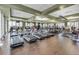 Modern fitness center featuring multiple treadmills, wood floors, and large windows for a bright workout environment at 2129 Palm Tree Dr, Poinciana, FL 34759