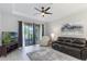 Cozy living room offers a sliding glass door to the outdoors, a ceiling fan, and a comfortable seating arrangement at 2129 Palm Tree Dr, Poinciana, FL 34759