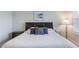 A spacious main bedroom with carpet flooring, a reading lamp, and a large bed at 2129 Palm Tree Dr, Poinciana, FL 34759