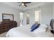 A bright main bedroom features a dark wood dresser, tray ceiling, and access to walk-in closet and bathroom at 2129 Palm Tree Dr, Poinciana, FL 34759