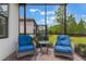 Inviting screened patio featuring comfortable wicker chairs with blue cushions and a glass-topped side table at 2129 Palm Tree Dr, Poinciana, FL 34759