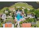 Aerial view of a resort-style pool surrounded by lush landscaping, lounge chairs, and nearby waterways at 2129 Palm Tree Dr, Poinciana, FL 34759