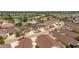 Expansive aerial view of a vibrant residential community with well-maintained homes and lush landscaping near a serene lake at 2403 Muirwood Pl, The Villages, FL 32162