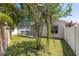 Lush backyard features a screened-in patio, green lawn, and a variety of trees and shrubs at 2403 Muirwood Pl, The Villages, FL 32162