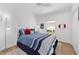 Bright bedroom with white walls, ceiling fan, lamp and bed with ocean-themed bedding at 2403 Muirwood Pl, The Villages, FL 32162
