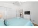 Bright bedroom with white walls, ceiling fan, white dresser, and bed with ocean-themed bedding at 2403 Muirwood Pl, The Villages, FL 32162