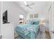Bright bedroom featuring a ceiling fan, nautical decor, and a comfortable bed with blue bedding at 2403 Muirwood Pl, The Villages, FL 32162