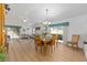 Well-lit dining area with wood floors and large windows, seamlessly connected to the living space at 2403 Muirwood Pl, The Villages, FL 32162