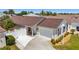 Aerial view of the home's exterior, driveway, garage, walkway, landscaping and front entry at 2403 Muirwood Pl, The Villages, FL 32162