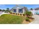 Well-manicured lawn and landscaping featuring trimmed bushes and palm trees accentuates the beauty of the property at 2403 Muirwood Pl, The Villages, FL 32162