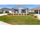 This well maintained home has attractive landscaping with green grass, mulch beds, and pruned bushes under the windows at 2403 Muirwood Pl, The Villages, FL 32162