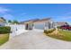 Charming single-story home featuring a two-car garage and a well-maintained front yard with white picket fence at 2403 Muirwood Pl, The Villages, FL 32162