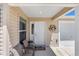 Inviting front porch features two comfortable chairs, a decorative welcome sign, and convenient access to the garage at 2403 Muirwood Pl, The Villages, FL 32162