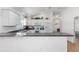 Bright, modern kitchen featuring white cabinets, stainless steel appliances, and a breakfast bar at 2403 Muirwood Pl, The Villages, FL 32162