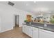 Open-concept kitchen with white cabinetry and a breakfast bar that connects to other rooms at 2403 Muirwood Pl, The Villages, FL 32162