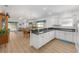 Open-concept kitchen and living area with light colored cabinets, a bar counter, and a large sliding glass door at 2403 Muirwood Pl, The Villages, FL 32162