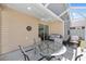 Covered patio featuring a glass table, four chairs and wicker couches for outdoor relaxation at 2403 Muirwood Pl, The Villages, FL 32162