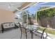 Covered screened-in patio with outdoor seating and a dining table, overlooking a green lawn at 2403 Muirwood Pl, The Villages, FL 32162