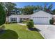 Charming single-story home with well-manicured lawn, mature trees, and a two-car garage at 2482 Ansley Path, The Villages, FL 32162