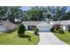 Inviting single-story home features a manicured lawn and a two car garage at 2482 Ansley Path, The Villages, FL 32162