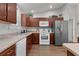 Bright kitchen featuring stainless steel appliances, wood cabinets, and an open layout for easy access and flow at 2482 Ansley Path, The Villages, FL 32162