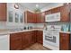 Bright kitchen with wood cabinets, laminate countertops, and modern appliances at 2482 Ansley Path, The Villages, FL 32162