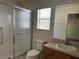 Bathroom features a tiled shower with a sliding door and natural light at 25801 Belle Helene, Leesburg, FL 34748