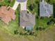 Aerial view of home featuring a screened pool, complemented by lush landscaping and mature palm trees in a well-manicured yard at 27027 Old English Ct, Leesburg, FL 34748