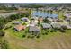 Aerial view of a well-manicured home and community with screened-in pool and lake at 27027 Old English Ct, Leesburg, FL 34748