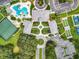 Top-down view of community clubhouse, pool, tennis, and bocce ball courts amidst manicured grounds, showing resort-style living at 27027 Old English Ct, Leesburg, FL 34748